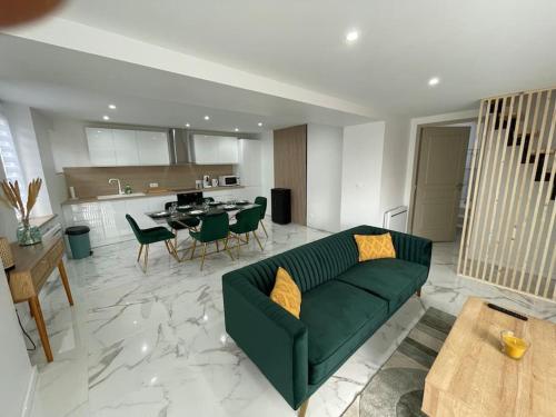 un salon avec un canapé vert et une cuisine dans l'établissement La maison de Carlos, à Gondrecourt-le-Château