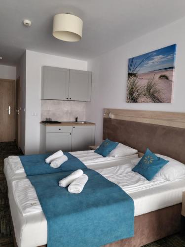 2 camas en una habitación de color azul y blanco en Apartament Suzi en Grzybowo