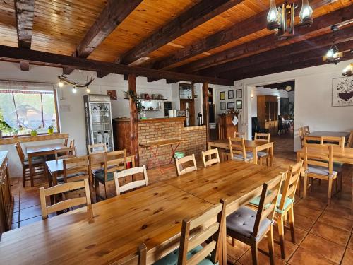 un comedor con una gran mesa de madera y sillas en Pensiunea Casa Gobbel, en Bran