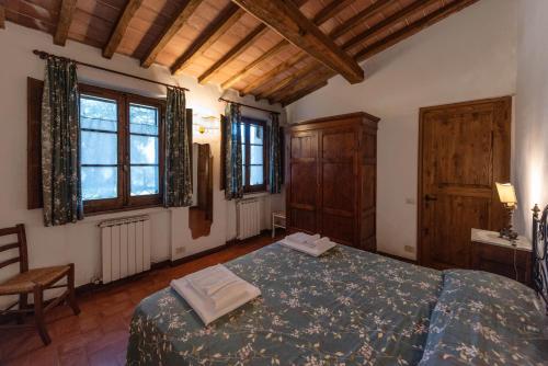 1 dormitorio con 1 cama, 1 silla y ventanas en Colombina, en Siena