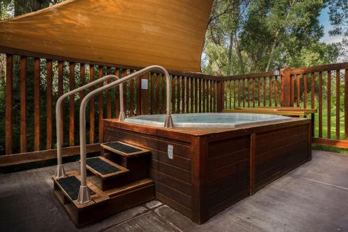 a hot tub on a deck with a wooden fence at Condo, Driggs - Bannock 216 in Driggs