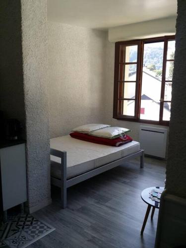 un lit dans une chambre avec une fenêtre dans l'établissement Charmant studio Argelès-gazost, à Argelès-Gazost