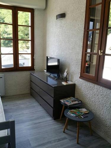 Cette chambre comprend un bureau avec une chaise et une table. dans l'établissement Charmant studio Argelès-gazost, à Argelès-Gazost