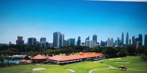 a view of a golf course in front of a city at 8 Kia Peng Suites KLCC by Luna in Kuala Lumpur