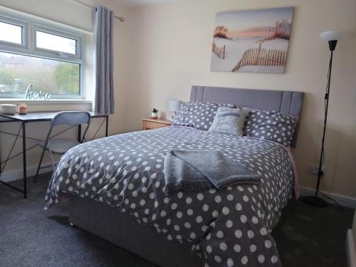 a bedroom with a bed and a desk and a window at Family friendly home near Alton Towers in Stoke on Trent