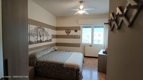 una camera con letto e ventilatore a soffitto di Casa Vacanze da Emanuela a Darfo