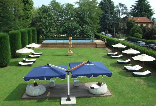 a group of umbrellas and chairs and a pool at Villa Moro Lin Design Apartments in Mestre