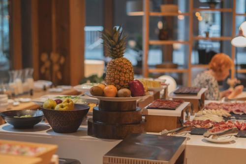 a table with a pineapple and other fruits on it at Zenit San Sebastián in Donostia-San Sebastián