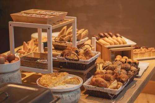 a table with various types of bread and pastries at Zenit San Sebastián in Donostia-San Sebastián