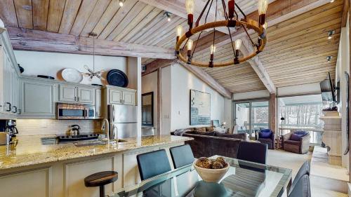 a kitchen and living room with a chandelier at Top of the Village - CoralTree Residence Collection in Snowmass Village