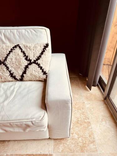 a white couch with a pillow on top of it at Les Suites d'Angoulême - Proche Gare et Centre ville - Haut de gamme in Angoulême