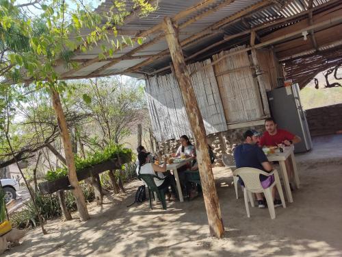 un groupe de personnes assises à des tables dans un pavillon dans l'établissement Hospedaje los polos, à Villavieja