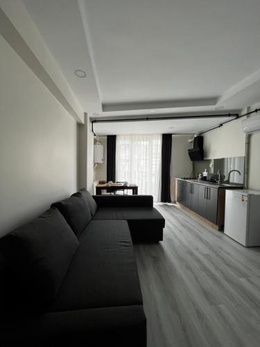 a living room with a black couch and a kitchen at Neva Residence in Istanbul