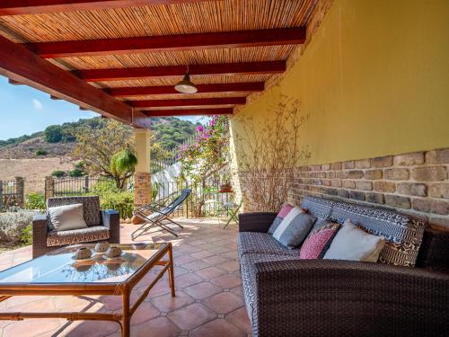 a patio with a couch and a table on a patio at Ollastu Apartments Villasimius in Villasimius
