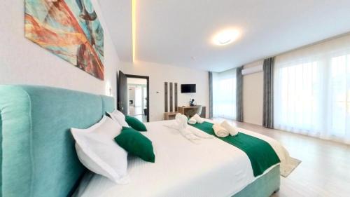 a bedroom with a large bed with green and white pillows at Vila Diamond Lux&Spa in Sovata