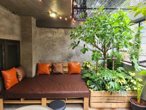 a couch in a room with lots of plants at House of Machine Boutique Hotel in Bangkok