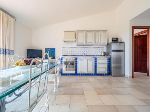 a kitchen with blue and white cabinets and a table at Ollastu Apartments Villasimius in Villasimius