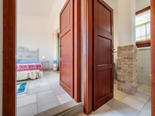 a wooden door in a room with a bedroom at Ollastu Apartments Villasimius in Villasimius