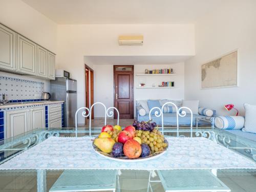 a bowl of fruit on a glass table in a kitchen at Ollastu Apartments Villasimius in Villasimius