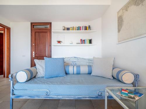 a blue couch in a living room with a glass table at Ollastu Apartments Villasimius in Villasimius