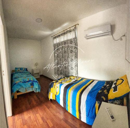 馬德普拉塔的住宿－Cabañas Atlantic Breeze，一间卧室设有两张床,其中设有窗户。