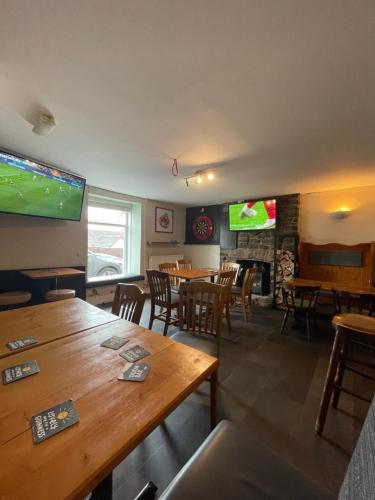 a restaurant with wooden tables and chairs and a television at The Fox and Hounds in Banc-y-felin