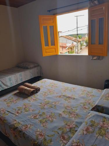 1 dormitorio con 2 camas y ventana en Casa Relva Suítes, en Lençóis