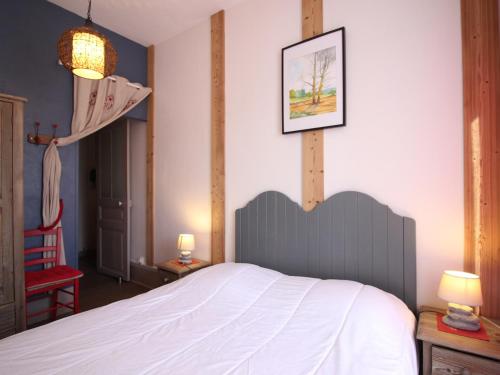 ein Schlafzimmer mit einem weißen Bett und einem roten Stuhl in der Unterkunft Appartement T3 au Mont-Dore, Centre, 3 étoiles, balcon, ascenseur, WIFI, proche Thermes et navette ski - FR-1-608-17 in Le Mont-Dore