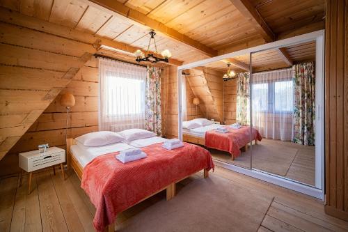 a bedroom with two beds in a log cabin at tatra wooden apartment in Ratułów