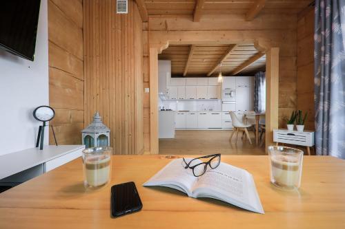 a table with an open book and glasses on it at tatra wooden apartment in Ratułów