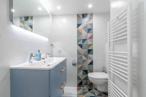 een witte badkamer met een wastafel en een toilet bij PENTHOUSE Luxe DISNEYLAND PARIS in Chessy