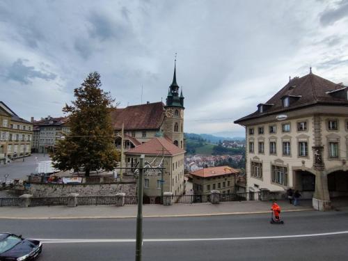 una calle de la ciudad con un edificio con una torre de reloj en Cosy appartement 1 chambre au coeur du bourg en Fribourg