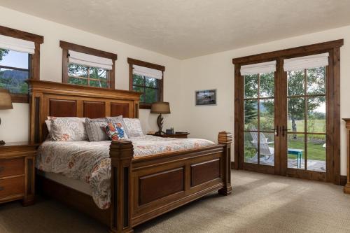 um quarto com uma cama com uma cabeceira em madeira e janelas em Month long Rental- Teton Springs Home, 4 Bedroom em Victor