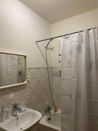 a bathroom with a shower curtain and a sink at Caminho da Vila moradia. in Escalos de Cima