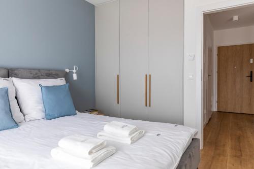 a bedroom with a bed with towels on it at Kamienica Parkowa in Dąbki