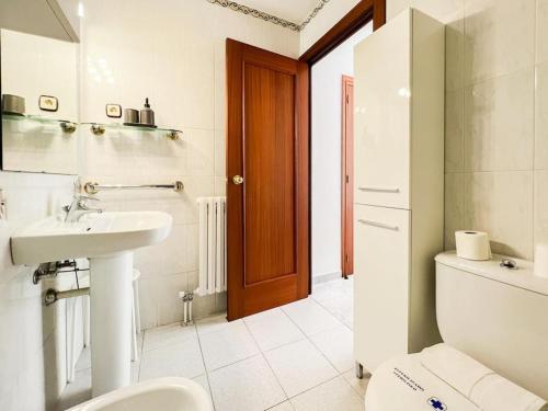 a white bathroom with a sink and a toilet at Amplio Apartmento en Pal. 8PAX in Pal