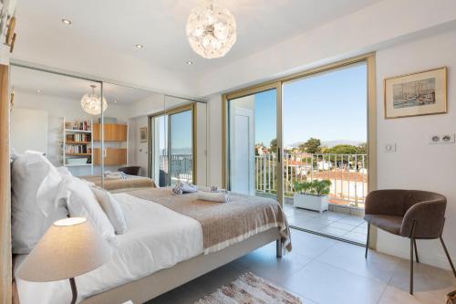 une chambre avec un lit et une grande fenêtre dans l'établissement Capleouna Le Saint-Alexandre, à Antibes