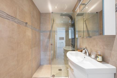 une salle de bain avec un lavabo et une douche en verre dans l'établissement Capleouna Le Saint-Alexandre, à Antibes