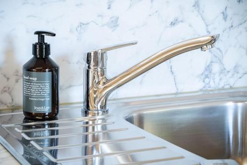 a bottle of soap sitting next to a sink at Appartement Mondholzliebe DG in Argenbühl