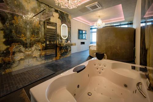 a bathroom with a large bath tub in a room at AGORA Tournai - Wellness Suites in Tournai
