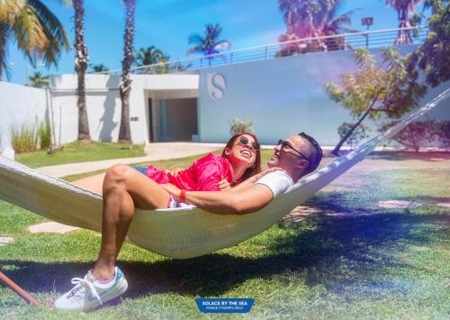 a man and a woman sitting in a hammock at Solace by the Sea in Ponce