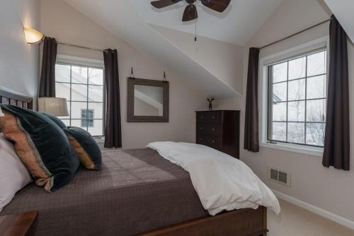 - une chambre avec un lit, un ventilateur de plafond et 2 fenêtres dans l'établissement The Woodland Townhome - Located on Ski Hill Road, à Driggs