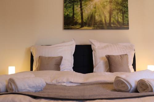 a large bed with white sheets and pillows at Chiemsee /Seeblick/ Netflix in Seeon-Seebruck