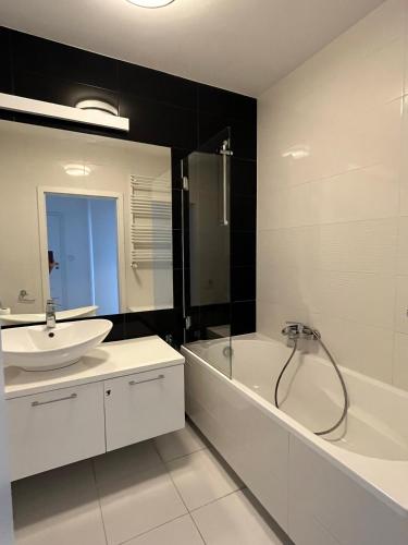 a bathroom with a tub and a sink and a bath tub at airport cybernetyki2 inn in Warsaw