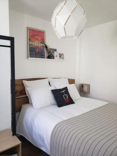 une chambre avec un grand lit avec des oreillers blancs dans l'établissement Le Lodge - Au coeur du village, à La Grave