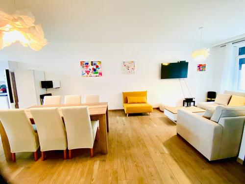 - un salon avec une table, des chaises et une télévision dans l'établissement Résidence Deluxe, à Charleroi