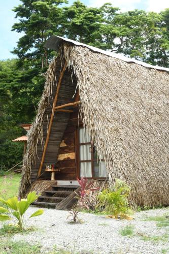 uma pequena cabana com um telhado de palha e uma janela em La Chantin em Pedregal