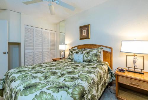 a bedroom with a bed and two lamps and a fan at Kihei Surfside 307 - MCH in Kihei