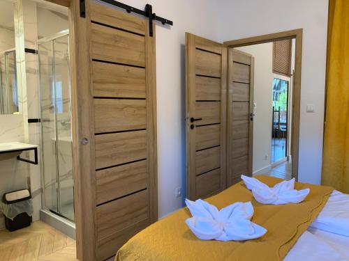 a bedroom with a bed with two white flowers on it at Apartament Kalina - Wyszyńskiego in Świeradów-Zdrój