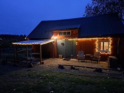 a cabin with a deck with lights on it at Guesthouse Nature Trails Sweden in Övre Älgestad